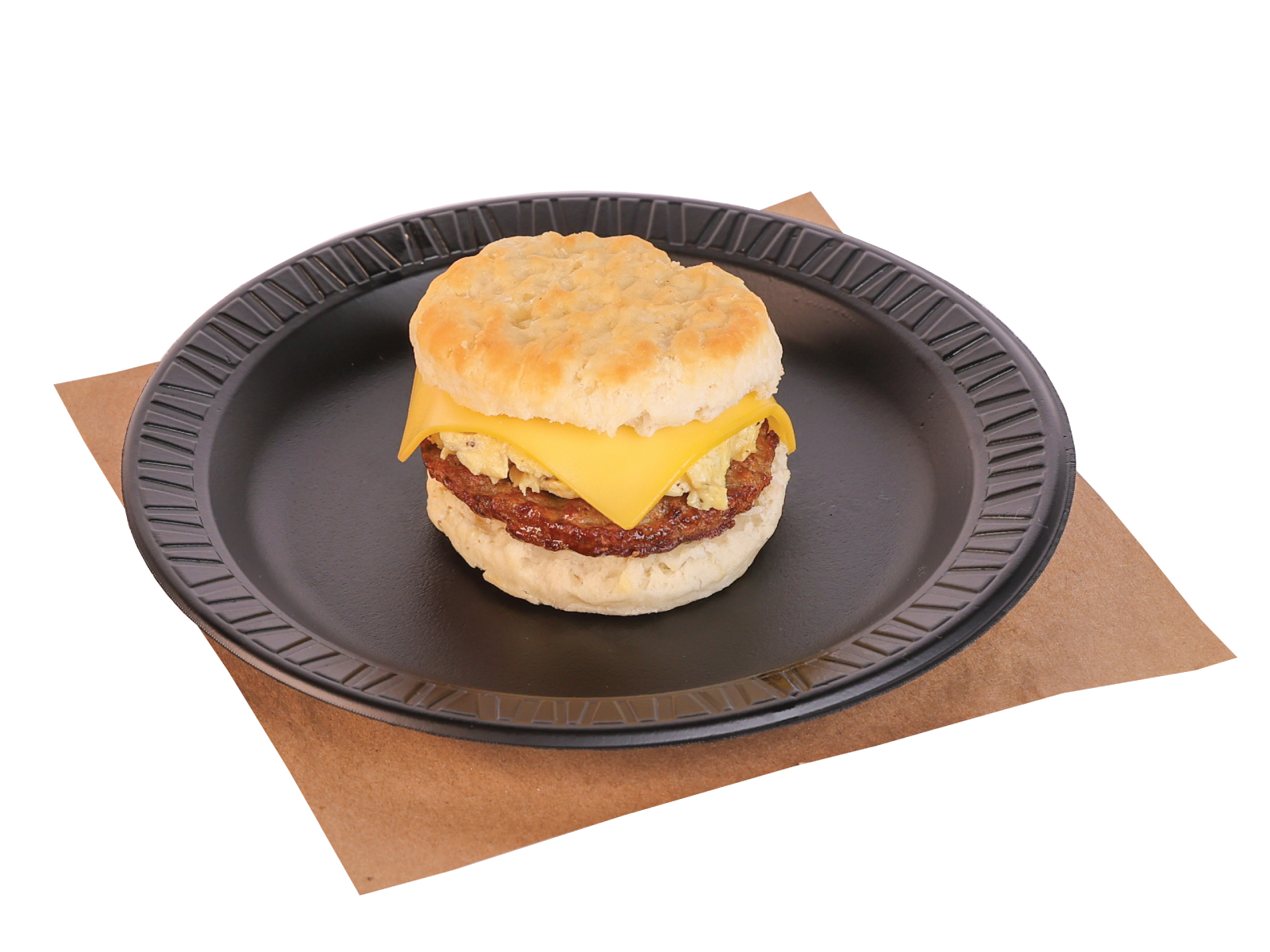 biscuit with cheese, egg, sausage patty on a black plate on top of butcher paper